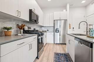 A modern kitchen with white cabinets and stainless steel appliances.at Coya Apartments, Las Vegas, NV, 89102