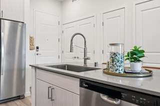 A modern kitchen with a stainless steel refrigerator and a black dishwasher.at Coya Apartments, Nevada, 891