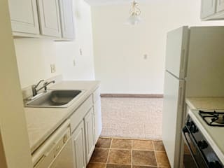 A kitchen with a sink, stove, and refrigerator.