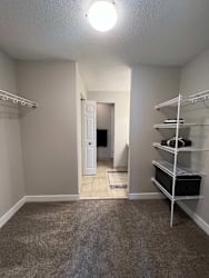 A room with a carpeted floor and a white door.