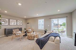 A living room with a couch, chairs, and a table.
