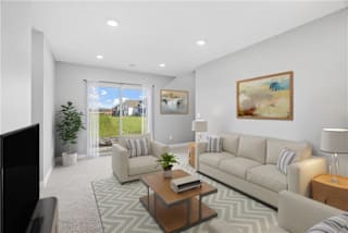 A living room with a couch, a coffee table, and a television.