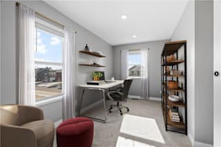 A modern home office with a desk, chair, and bookshelf.