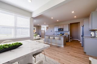 A modern kitchen with a marble countertop and wooden flooring.