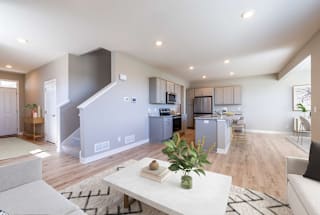 A modern kitchen with a dining area and a living room.
