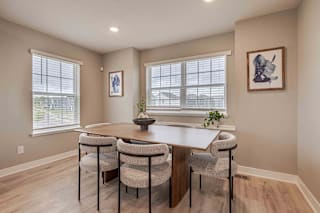 A dining room with a table and chairs.