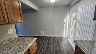 a kitchen and living room with wood flooring and a window