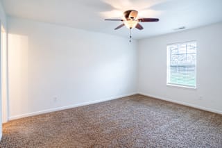 an empty room with a ceiling fan and a window at Barton Farms in Greenwood, IN 46143