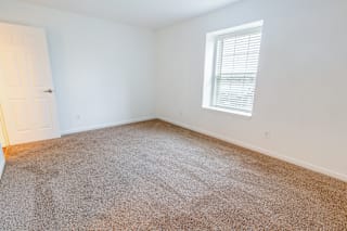 an empty room with carpet and a window at Barton Farms in Greenwood, IN 46143