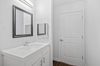 a bathroom with a sink and a mirror and a door