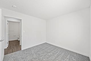 an empty room with white walls and a door to a bathroom