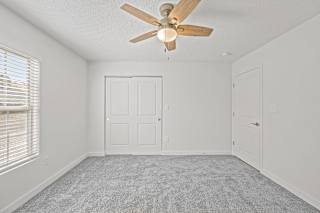 an empty room with a ceiling fan and a door