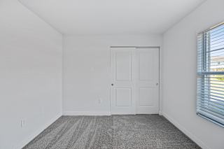 an empty room with white walls and a door and window