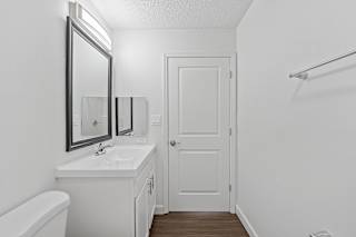a bathroom with a sink and a mirror and a door