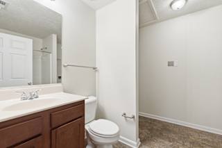 A white bathroom with a toilet, sink, and shower.