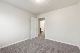 A room with a carpeted floor and a white door.