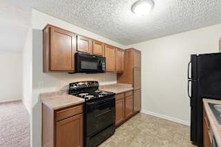 A kitchen with black appliances and wooden cabinets.