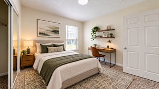 A bedroom with two beds, a desk, and a chair.