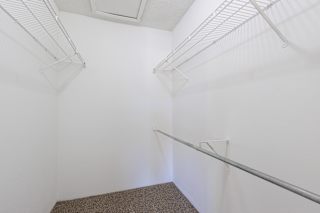 Empty closet in a model unit with white walls and a closet rail.