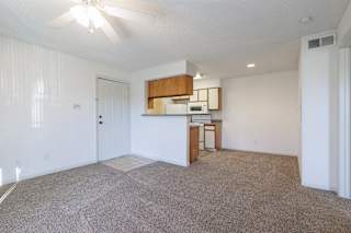 Empty living room and kitchen at Skyler Ridge with an open layout and ceiling fan.