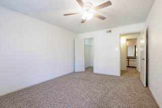 Empty model unit bedroom at Skyler Ridge featuring a ceiling fan and a large closet.