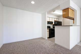 Model unit kitchen and dining area at Skyler Ridge with black appliances and open dining space.