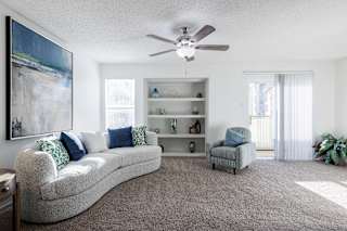 A model unit living room at Skyler Ridge Complex, with a dresser and a mirror on the wall.
