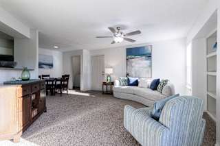 A spacious living room in a model unit at Skyler Ridge Complex, featuring an open layout and natural light.