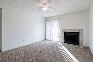 A spacious living room in a model unit at Skyler Ridge Complex, featuring an open layout and natural light.