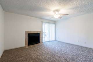 A spacious living room in a model unit at Skyler Ridge Complex, featuring an open layout and natural light.