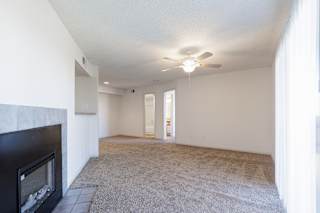 An empty living room in a model unit at Skyler Ridge Complex, featuring an open layout and natural light from large windows.