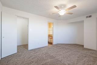 Spacious model bedroom at Skyler Ridge featuring neutral carpeting and a ceiling fan.