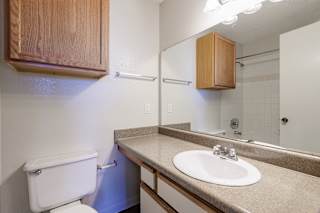 Clean model unit bathroom at Skyler Ridge featuring a vanity sink, large mirror, and neutral finishes.