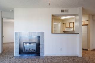 A well-lit, empty living room in a model unit at Skyler Ridge Complex, offering an open layout and plenty of space.