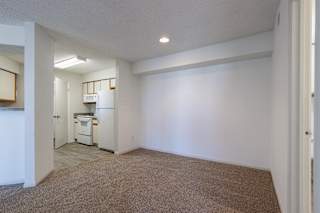 Well-equipped model unit kitchen featuring white appliances and an open dining space.