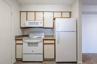Well-equipped model unit kitchen at Skyler Ridge with white appliances, a refrigerator, and a stove.