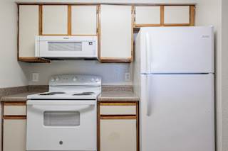 Well-equipped model unit kitchen at Skyler Ridge with white appliances, a refrigerator, and a stove.