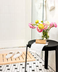 A small table with a vase of flowers and a book on it.