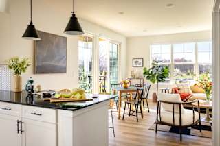 a kitchen with a counter top and a dining room with a table and chairs