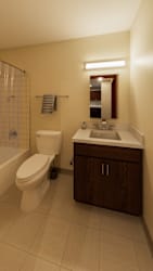 A bathroom with a toilet, sink, and mirror.