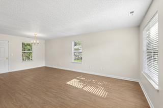 A room with wooden flooring and a window with blinds.