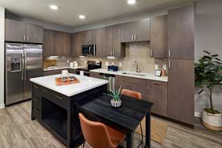 A kitchen with a table and chairs in the middle.