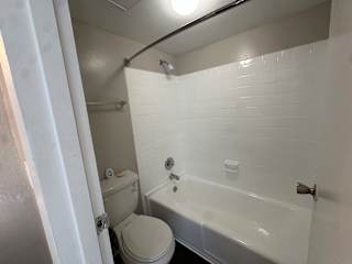 A white bathroom with a toilet, sink, and bathtub.at Auburn Glen Apartments, Jacksonville