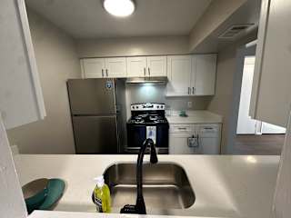 A kitchen with a stainless steel sink and a black vacuum cleaner.at Auburn Glen Apartments, Jacksonville