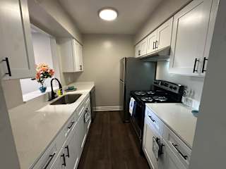 A kitchen with white cabinets and a black stove top oven.at Auburn Glen Apartments, Jacksonville