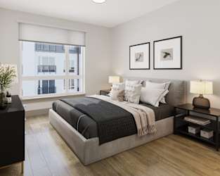 a bedroom with a bed and two windows at Bemiston Place Apartments, Missouri