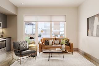 a living room with a couch and a chair and a table at Bemiston Place Apartments, Missouri, 63105