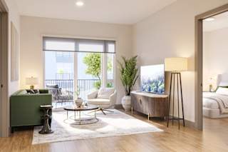 a living room with a couch and a chair and a tv at Bemiston Place Apartments, Clayton, MO