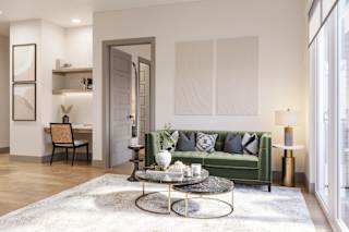 a living room with a green couch and a coffee table at Bemiston Place Apartments, Missouri