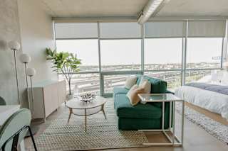 A living room with a green couch and a glass table. at One Foundry Way Apartments, St Louis, 63110
